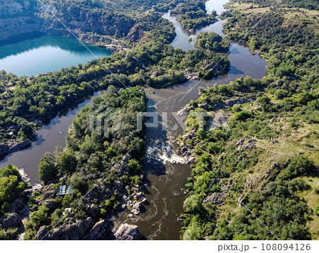 Radon lake near the Southern Bug river on a sunny summer day. Picturesque landscape from a bird's eye view. Flooded granite quarry. Radon lake near the Southern Bug river on a sunny summer day. Picturesque landscape from a bird's eye view. Flooded granite quarry. 108094126