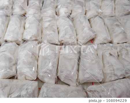 A large number of transparent sachets filled with white powder. White powder packaged in small sachets. A large number of transparent sachets filled with white powder. White powder packaged in small sachets. 108094229