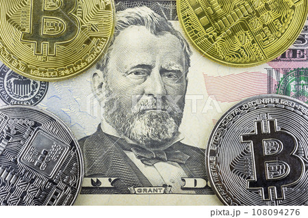 Bitcoin coins lie on a fifty dollar bill Bitcoin coins lie on a fifty dollar bill 108094276