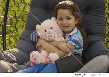 portrait of a little girl hugging a teddy bear 108094279