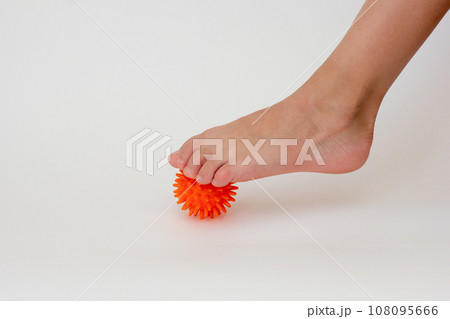 Cropped child leg doing exercises with spiky needle ball Cropped child leg doing exercises with spiky needle ball 108095666