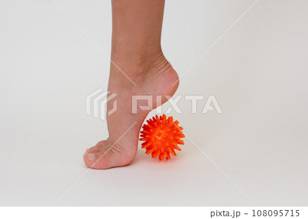 Cropped child leg doing exercises with spiky needle ball Cropped child leg doing exercises with spiky needle ball 108095715