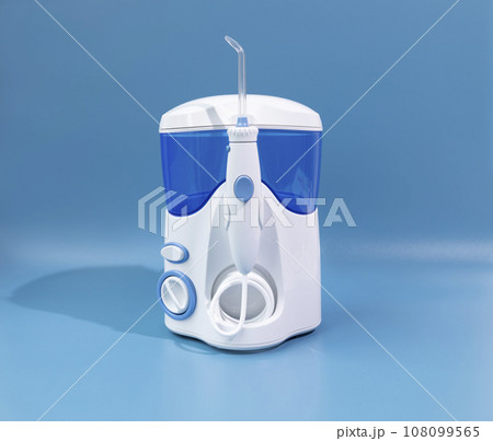 Water Flosser, Dental Oral Irrigator On Blue Background. Dental Equipment Care. Irrigator For Mouth. Cleaning Teeth With Water Jet Under Pressures. Horizontal Plane. Water Flosser, Dental Oral Irrigator On Blue Background. Dental Equipment Care. Irrigator For Mouth. Cleaning Teeth With Water Jet Under Pressures. Horizontal Plane. 108099565