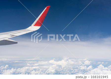上空を飛行中の飛行機の翼と眼下の景色 108101945