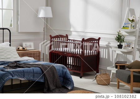a bed room with a crib a bed room with a crib 108102382
