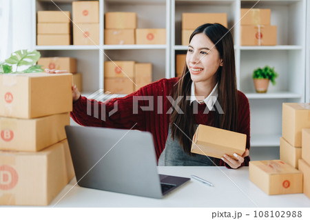 Asian female business owner handles delivery of orders to customers. Asian female business owner handles delivery of orders to customers. 108102988