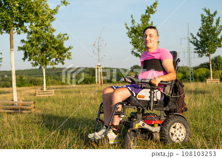 Portrait of disabled man in electric wheelchair in the park.  108103253