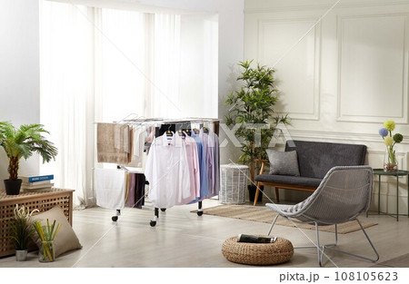 Laundry drying rack,  white pillow on bed 108105623