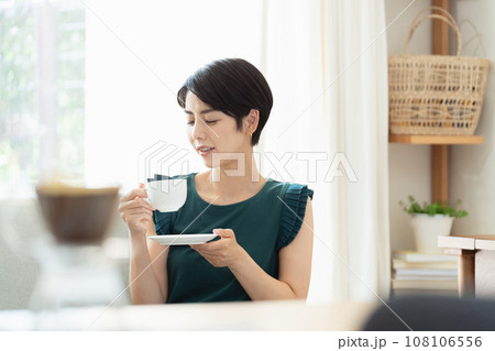 リビングでコーヒーを飲む女性 リビングでコーヒーを飲む女性 108106556