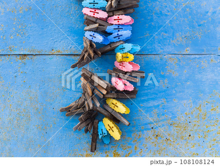 Clothespins on a rope on a blue shabby wall background.  108108124