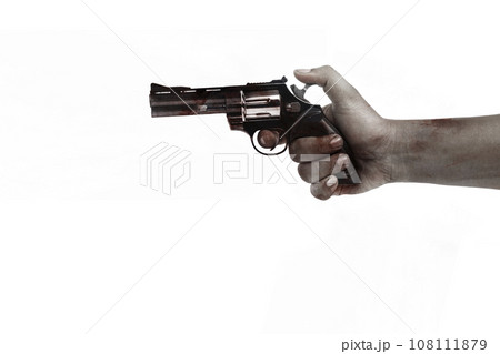 The hand of a scary zombie with blood and wounds carrying a handgun 108111879