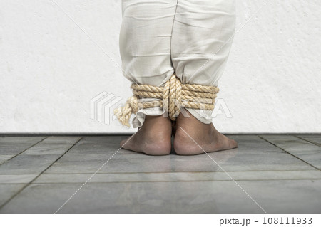 The man's legs are tied by rope The man's legs are tied by rope 108111933