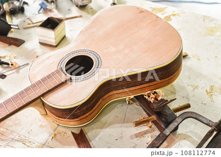 Many unfinished wooden drying guitars in workshop 108112774