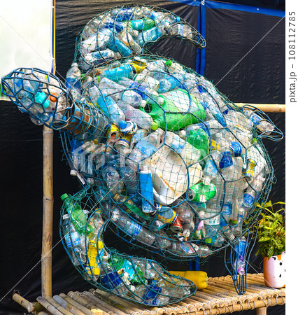 turtle-shaped trash can full of plastic bottles and cans as a propaganda of ecology 108112785