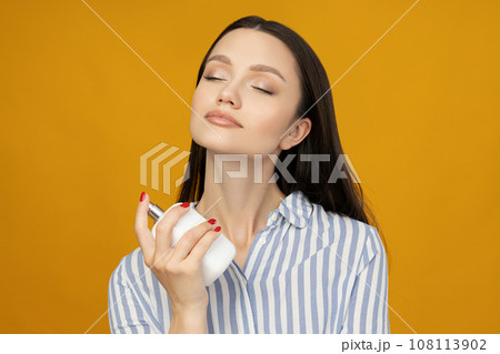 Attractive girl in a shirt with perfume in her hand 108113902