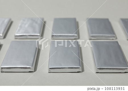 Chocolates in silver foil on gray background, close up 108113931