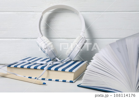 Headphones, books and pencil on white wooden background 108114176