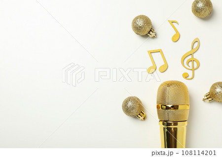 Golden microphone with notes on a light background. 108114201