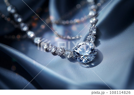 Luxury jewelry, platinum necklace with diamonds on dark silk fabric close-up. Golden necklace in the store. Beautiful diamond pendant necklace. Jewelry showcase, selective focus 108114826