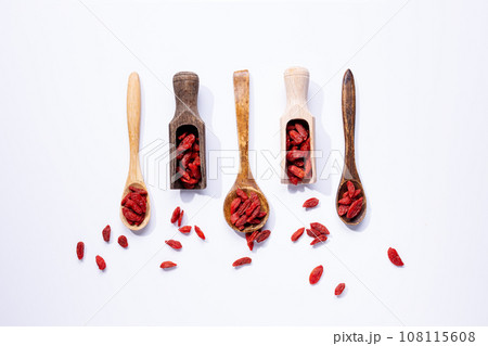 Dried goji berries on wooden spoons isolated on white background. Dried goji berries on wooden spoons isolated on white background. 108115608
