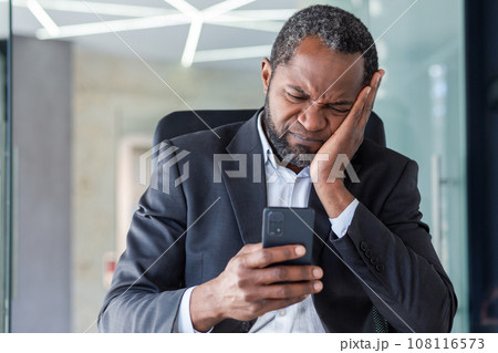 Upset man received online notification message with bad news, boss disappointed in despair reading news online using app on smartphone, businessman at workplace inside office. 108116573