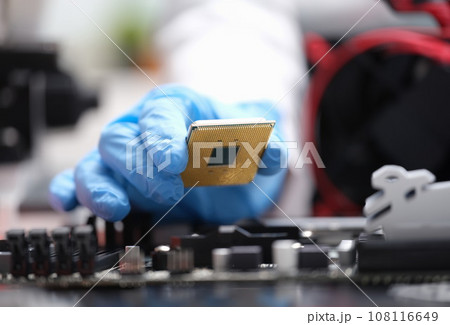 Repairman installing computer processor into motherboard closeup Repairman installing computer processor into motherboard closeup 108116649