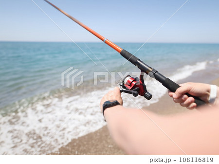 Man fishing with rod on seashore closeup 108116819