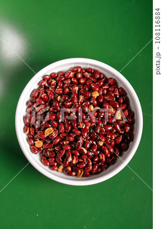 paintfu and red roasted peanuts in a white bowl on a green background.Chinese cuisine, hotpot ingredient paintfu and red roasted peanuts in a white bowl on a green background.Chinese cuisine, hotpot ingredient 108116884
