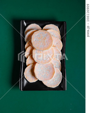 sweet potato slices on a black plate. View from above. Chinese cuisine, ingredient for hotpot 108116909
