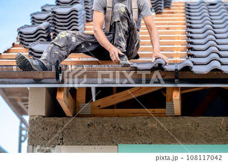 construction work on the roof of a family house, fired ceramic tiles on wooden beams 108117042