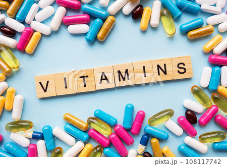 Health and medicine concept. Different colorful pills for different symptoms, in the middle - the inscription vitamins in wooden letters. Health and medicine concept. Different colorful pills for different symptoms, in the middle - the inscription vitamins in wooden letters. 108117742