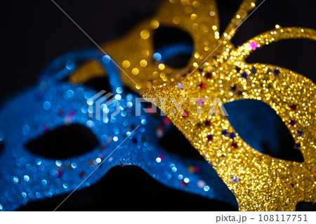 Luxurious Venetian shiny masks on a dark background. Carnival masquerade fantasy mask. Holiday and party concept. Blurred photo. Luxurious Venetian shiny masks on a dark background. Carnival masquerade fantasy mask. Holiday and party concept. Blurred photo. 108117751