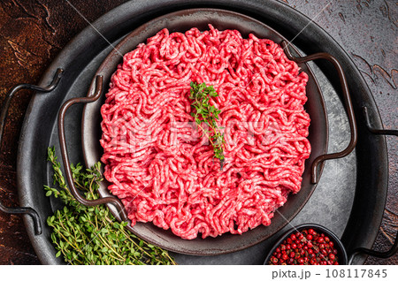 Raw Mince, minced Ground beef meat in a kitchen tray. Dark background. Top view Raw Mince, minced Ground beef meat in a kitchen tray. Dark background. Top view 108117845