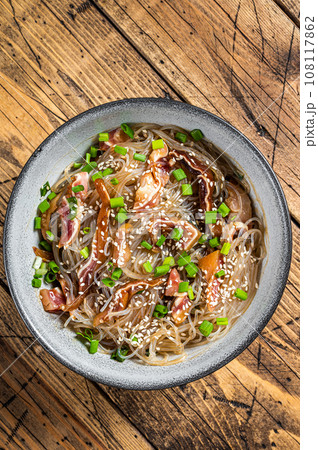 Spicy salad with pork pig ears, glass noodles, sesame seeds and green onions. Wooden background. Top view 108117862