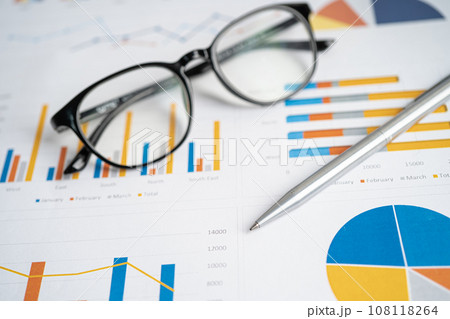 Eyeglass with pen on chart graph paper. Finance, account, statistic, investment data economy, stock exchange business. Eyeglass with pen on chart graph paper. Finance, account, statistic, investment data economy, stock exchange business. 108118264