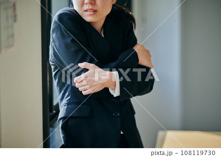 窓際で体が震える冷え性の若い女性会社員 108119730