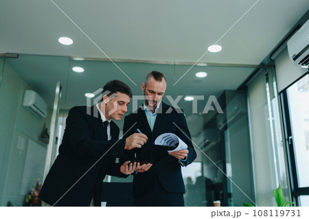 Two business men meeting to talking or discuss marketing work in workplace using paperwork, calculator, computer to work 108119731