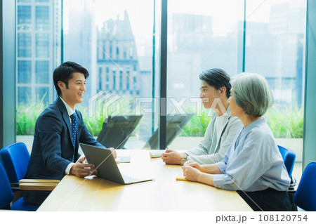 ミドル夫婦に説明するスーツの男性 108120754
