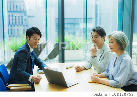 ミドル夫婦に説明するスーツの男性 108120755