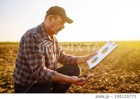 Expert hand of farmer checking soil health before growth a seed of vegetable or plant seedling. Expert hand of farmer checking soil health before growth a seed of vegetable or plant seedling. 108120773