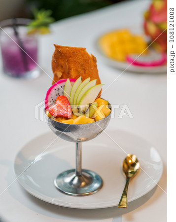 Tropical Paradise sorbet with grapefruit, mango, passion fruit decorated with fresh fruit and crispy tuile cookies. Tropical ice cream in metal sundae bowl. Summer ice cream concept Tropical Paradise sorbet with grapefruit, mango, passion fruit decorated with fresh fruit and crispy tuile cookies. Tropical ice cream in metal sundae bowl. Summer ice cream concept 108121008