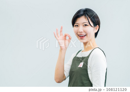OKポーズを取る飲食店で働くアルバイト女性 白バック OKポーズを取る飲食店で働くアルバイト女性 白バック 108121120