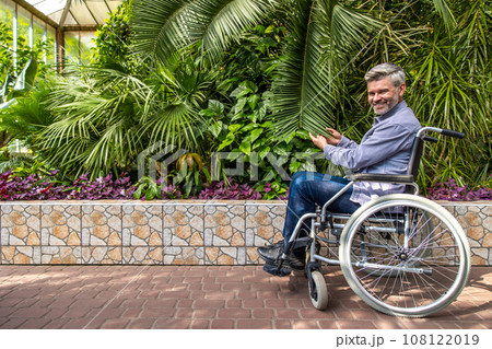 Gray-haired man on a wheelchair in a park Gray-haired man on a wheelchair in a park 108122019