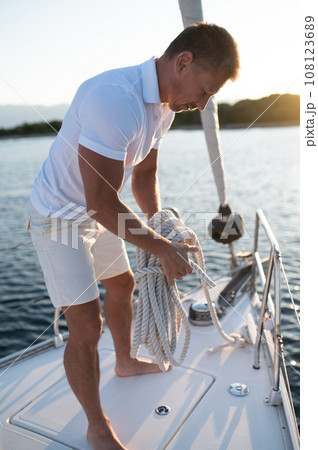 Man on a yacht getting ready for traveling Man on a yacht getting ready for traveling 108123689