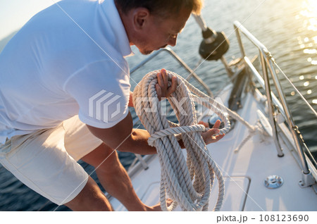 Man on a yacht getting ready for traveling Man on a yacht getting ready for traveling 108123690