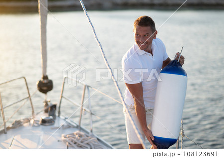 Man on a yacht getting ready for traveling Man on a yacht getting ready for traveling 108123691