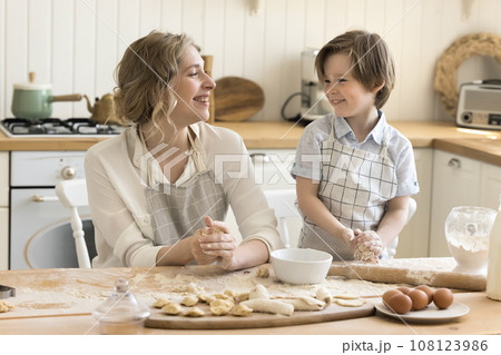 Mom and little son prepare pastries together 108123986