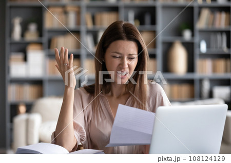 Indignant woman reading letter received bad news from bank 108124129