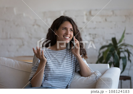 Cheerful millennial user woman speaking on mobile phone at home 108124183