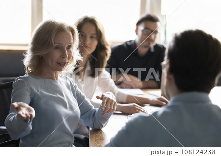 Mature business woman talks to project manager in boardroom Mature business woman talks to project manager in boardroom 108124238
